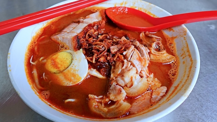 Bowl of 888 Hokkien prawn mee with dark broth and fresh prawns