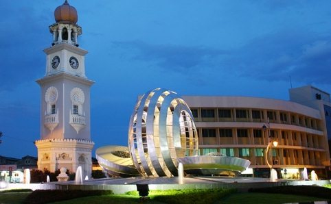Colonial buildings lit up at night along the Esplanade in George Town