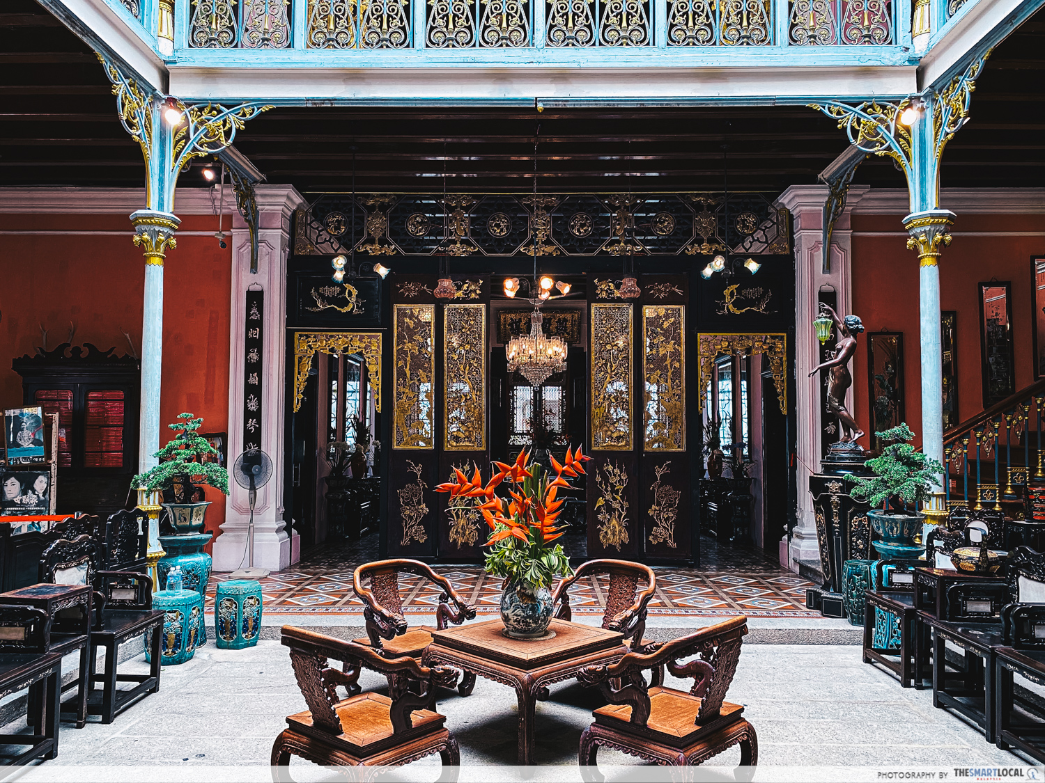 Ornate interior of Pinang Peranakan Mansion showing antique furniture and tile floors