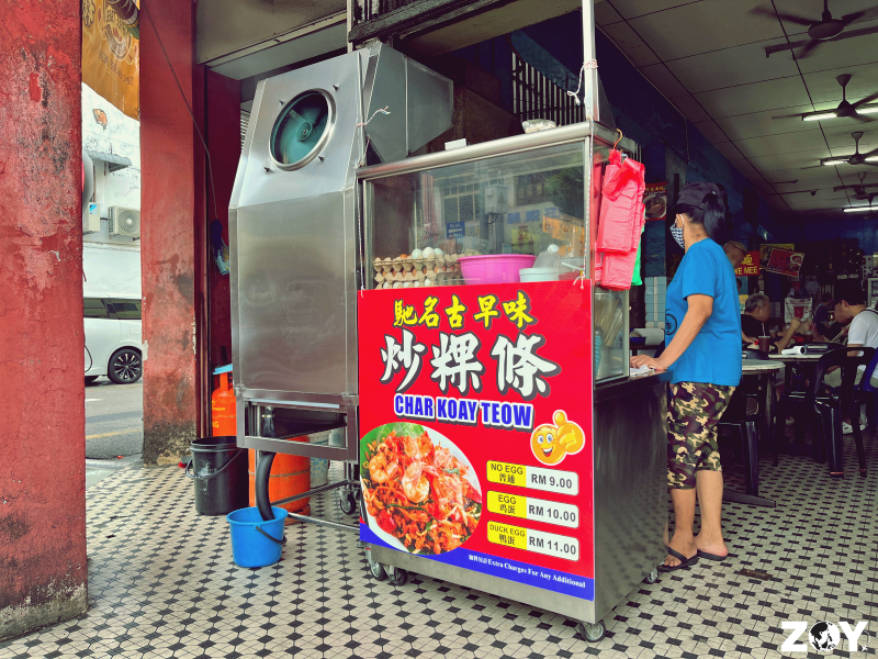 Tiger char koay teow with a slightly darker, smokier char on the noodles, under evening lights